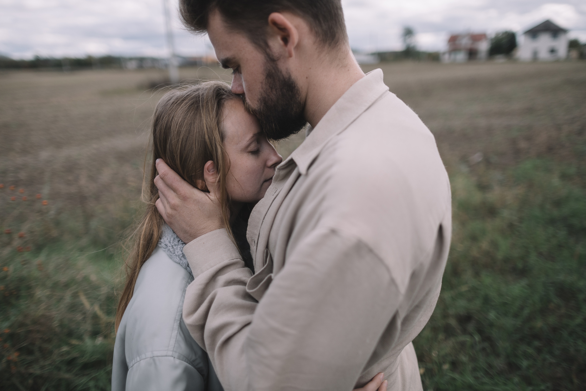 Man Kissing His Girlfriend's Forehead Outdoors